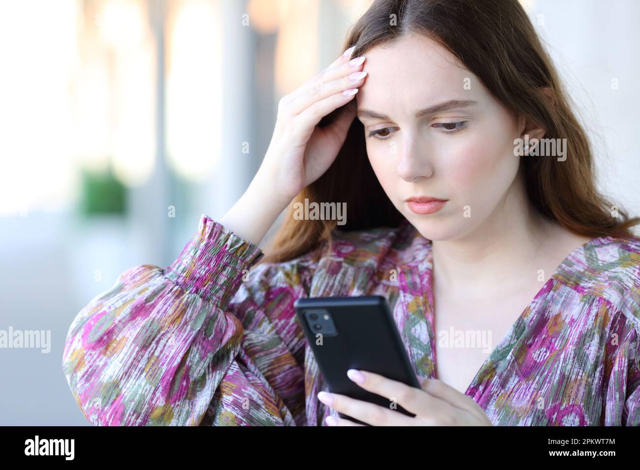 Worried Woman Using Smart Phone Standing In The Street Stock Photo - Alamy