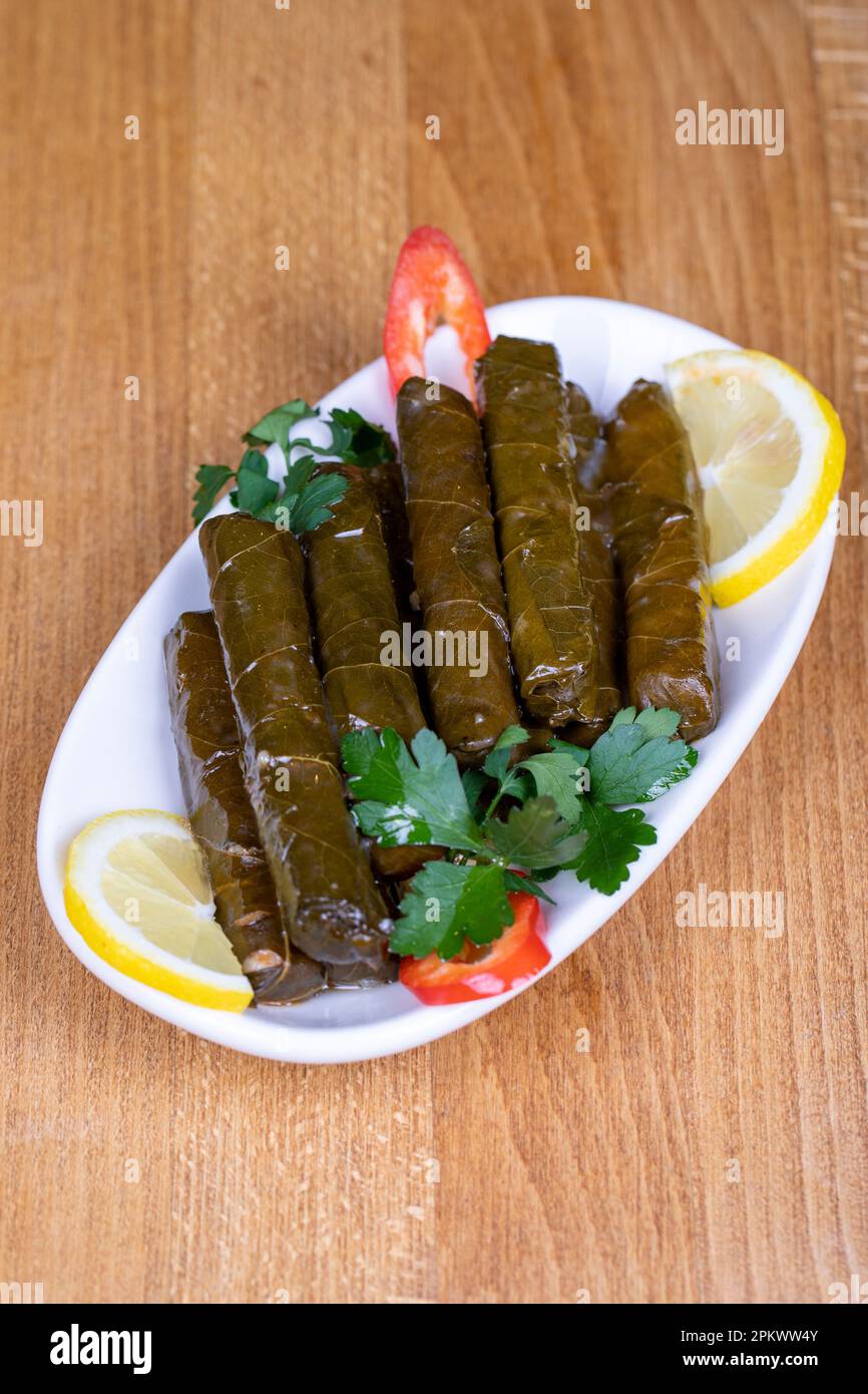 Turkish leaf wrap. Grape leaf wrap with olive oil on wood background