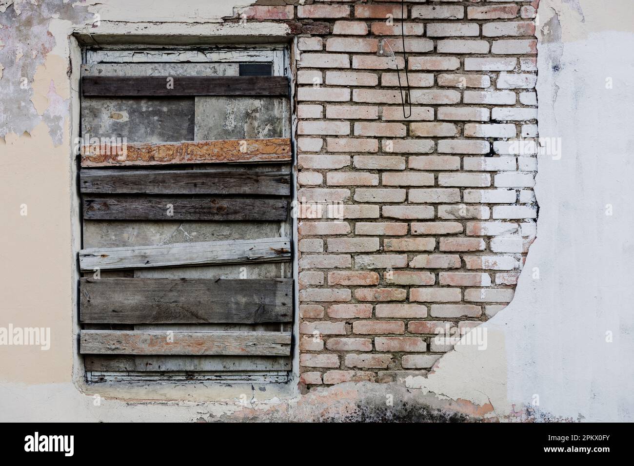 Boarded-up window in an abandoned old building. rustic brick house on ...
