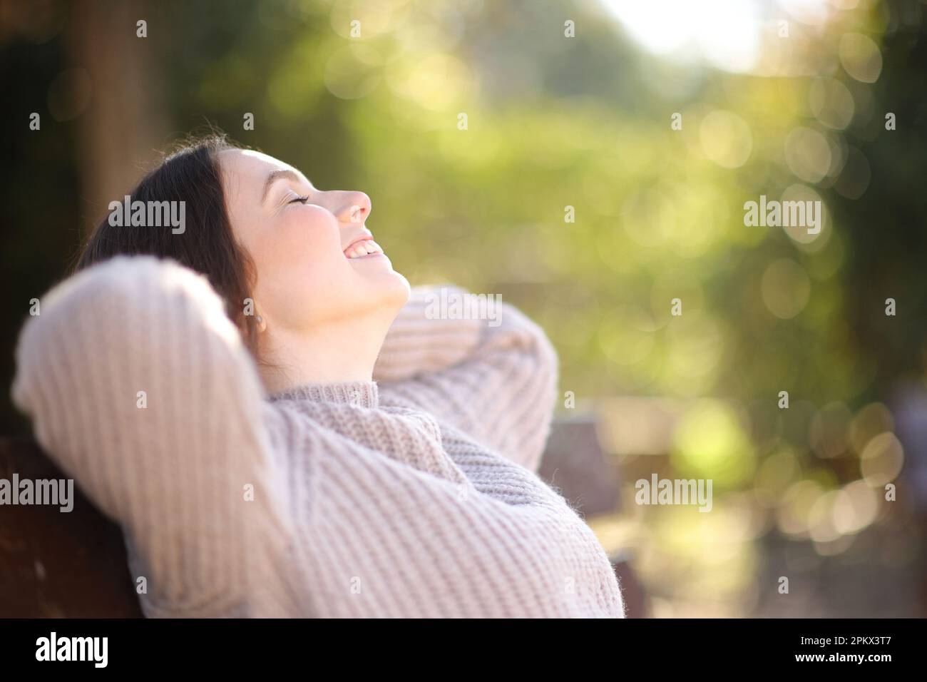 Profile of a relaxed woman resting sitting on bench in a park Stock Photo