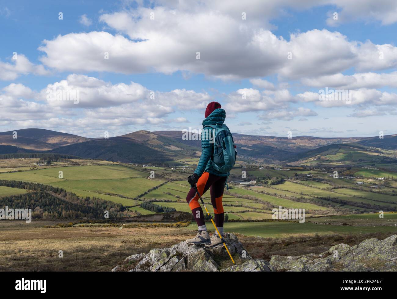 female hiker standing on top of mountain admiring landscape Stock Photo