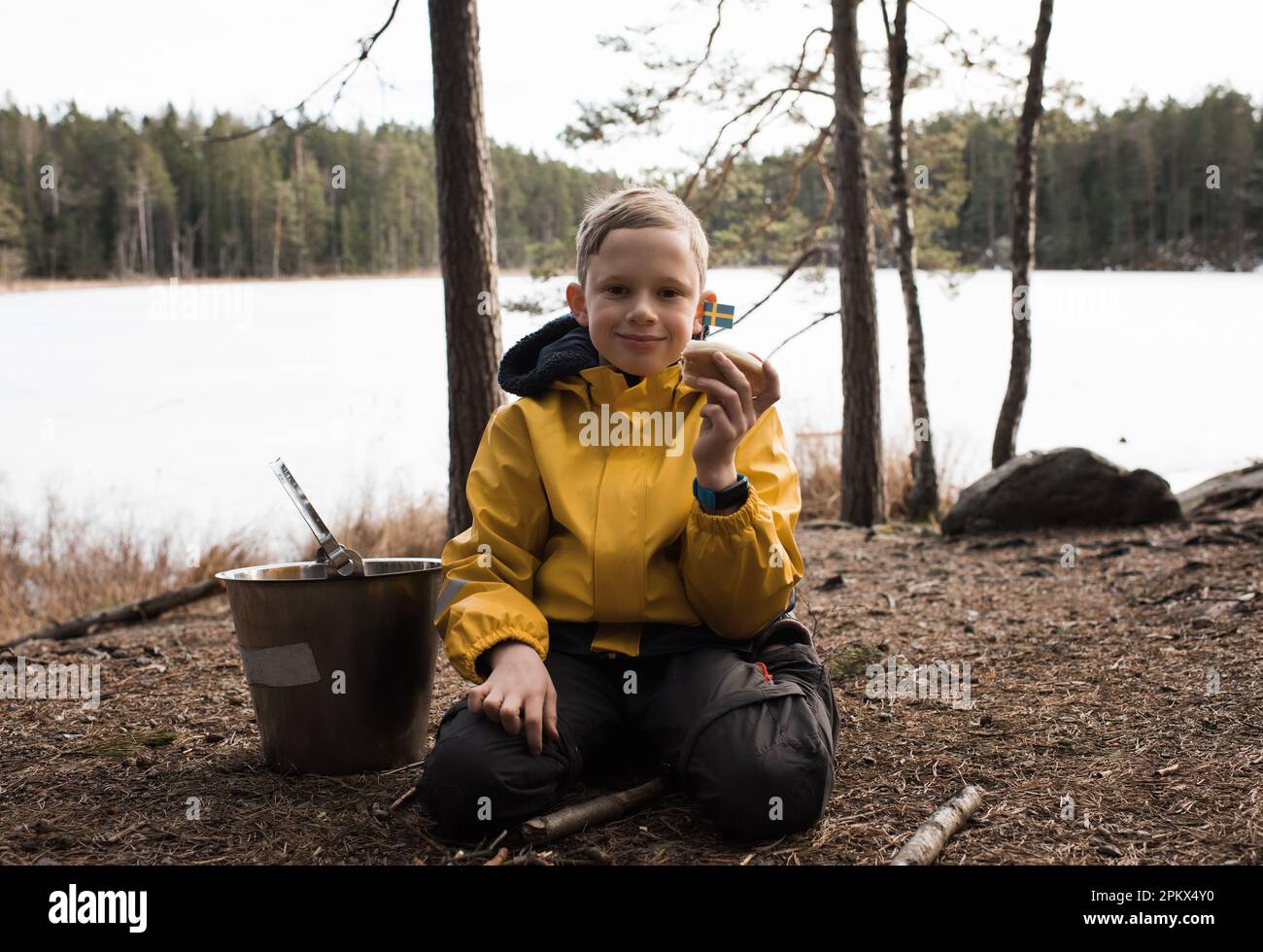 Swedish boy holding a hot dog with a Swedish flag in a national park Stock Photo