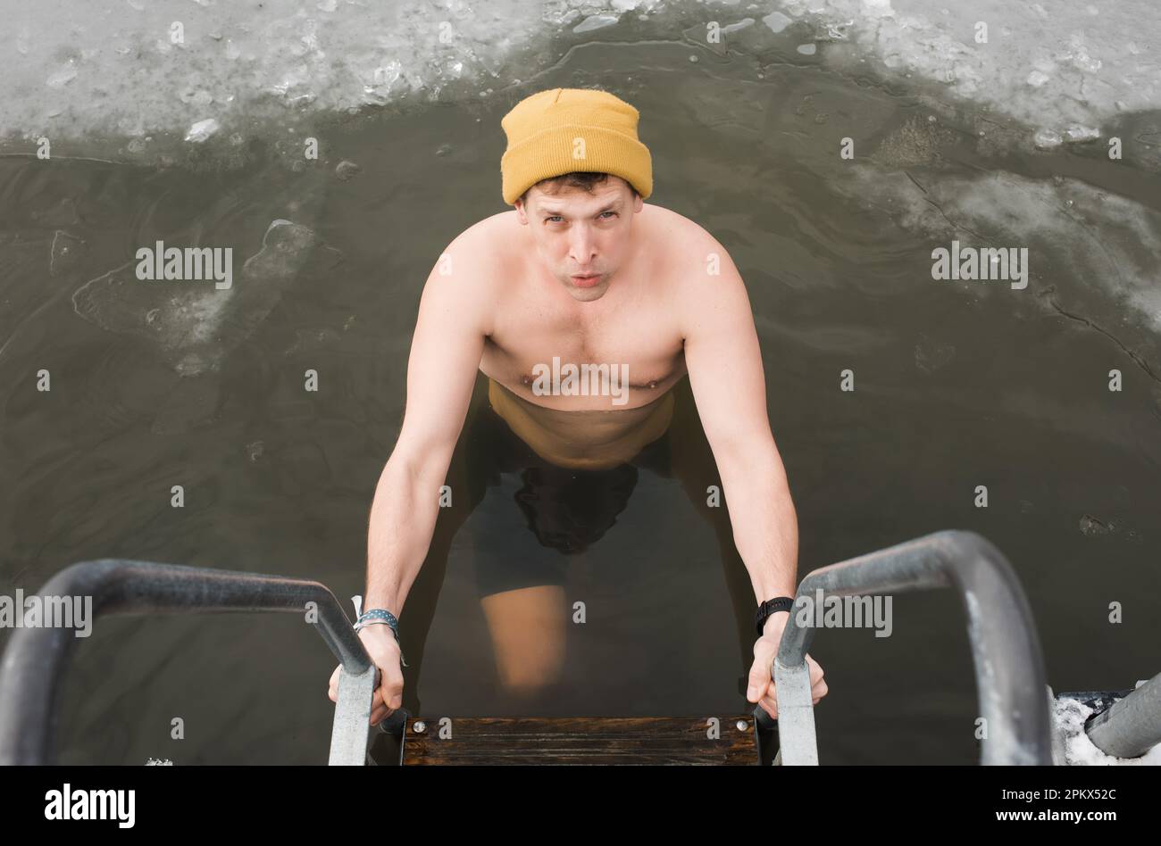 man swimming in frozen cold water in Sweden Stock Photo