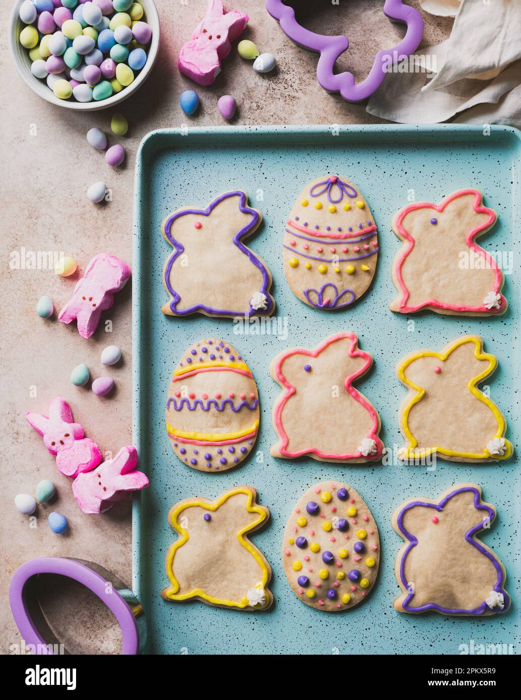 easter cookies shaped like eggs and bunnies on green tray from above. Stock Photo