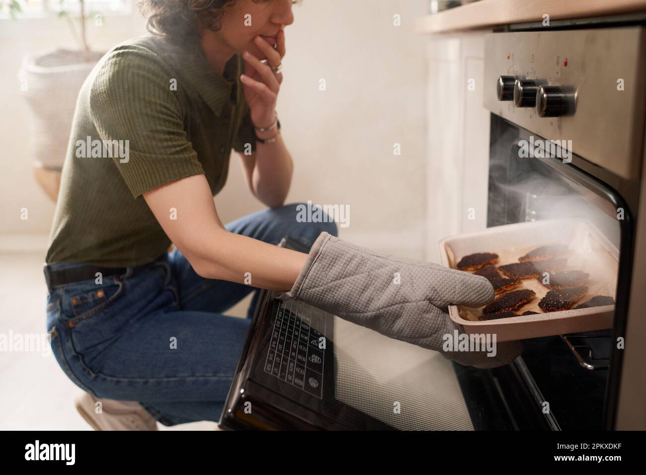 Housewife cooking in the kitchen taking the burnt food on pan out of