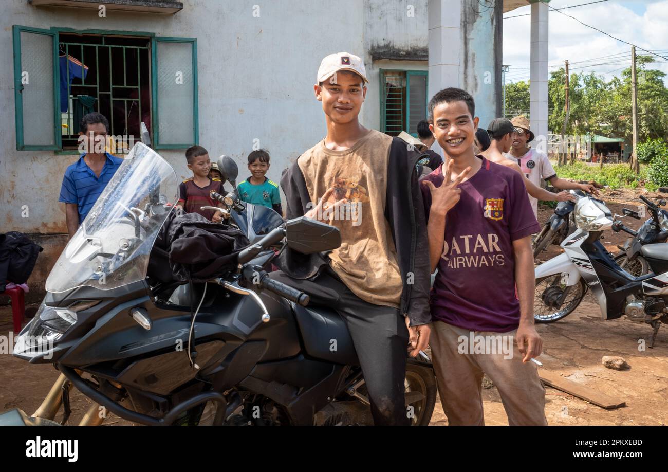 Two young Jerai ethnic minority men pose next to a large motorcycle Ia Pia, in the Central Highlands of Vietnam. Stock Photo