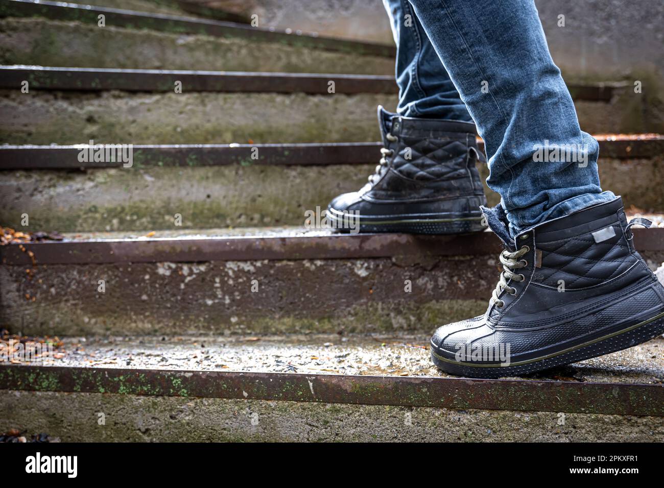 A man in boots on the old steps, close-up. Stock Photo