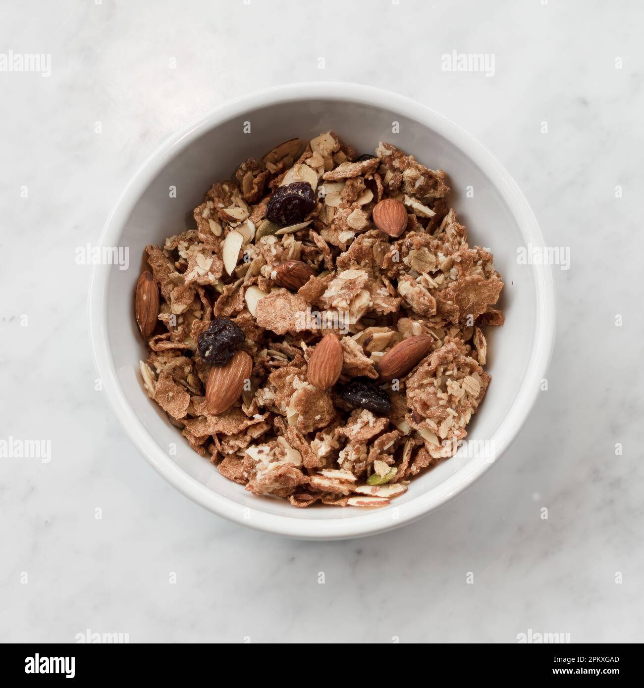 A top view of a bowl of healthy cereal with nuts and oats Stock Photo