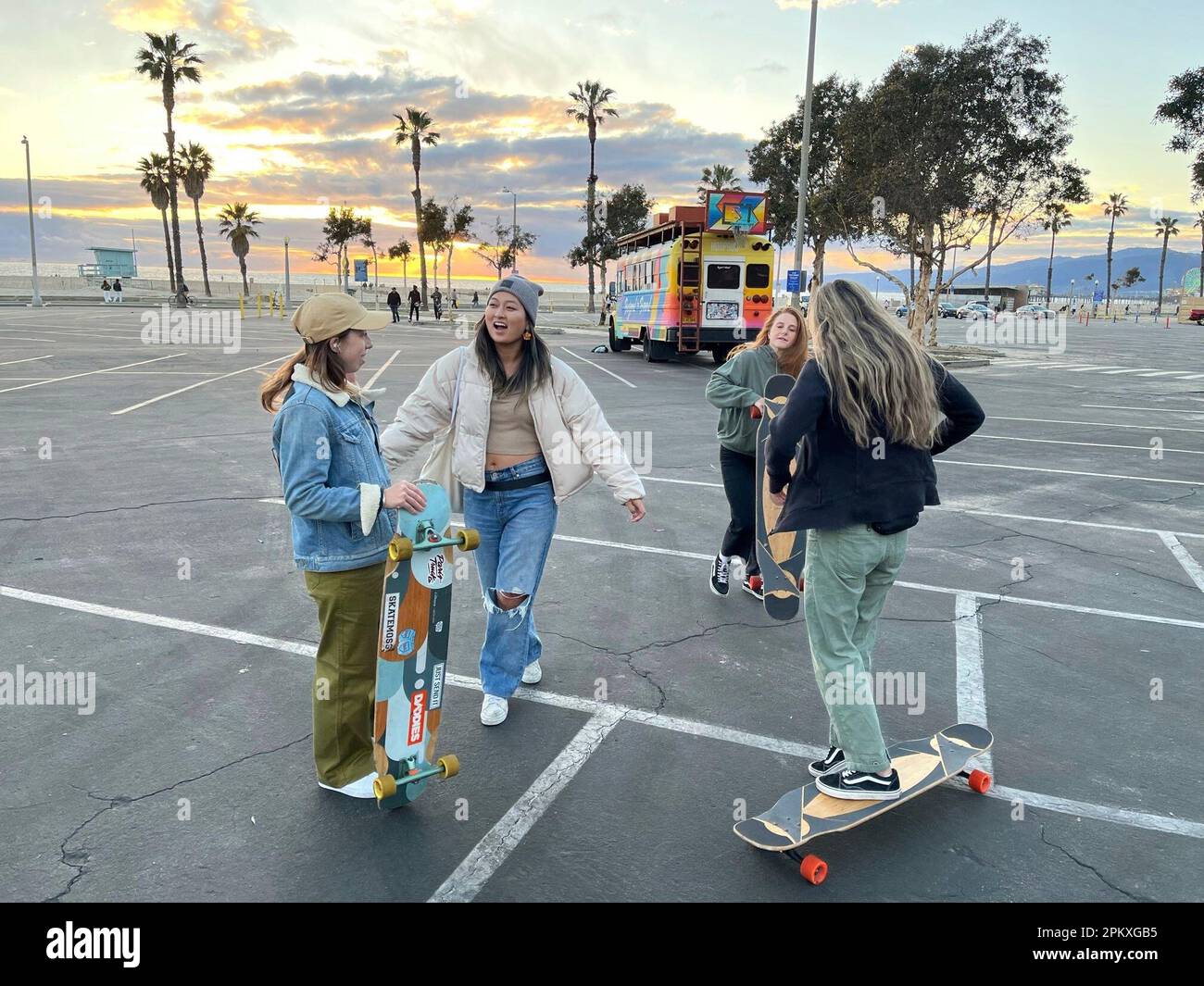 Hannah Dooling, from left, Jane Kang, Christie Goodman, and Yun Huang  gather in a vacant parking lot to practice longboarding in Santa Monica,  Calif., on Feb. 26, 2023. Longboard dancing is still