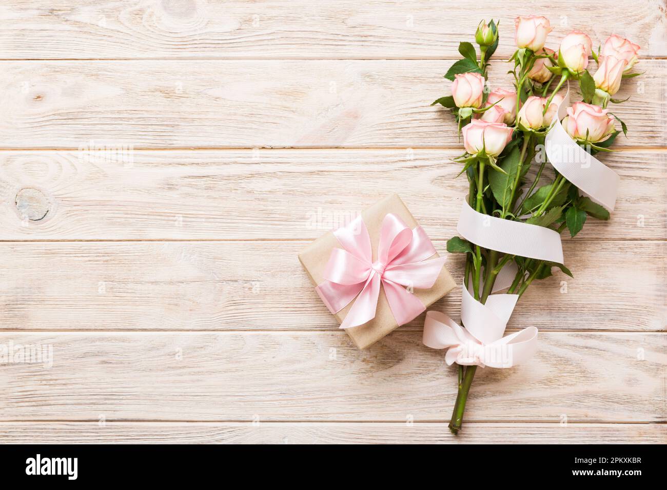 design concept with pink rose flower and gift box on colored table ...
