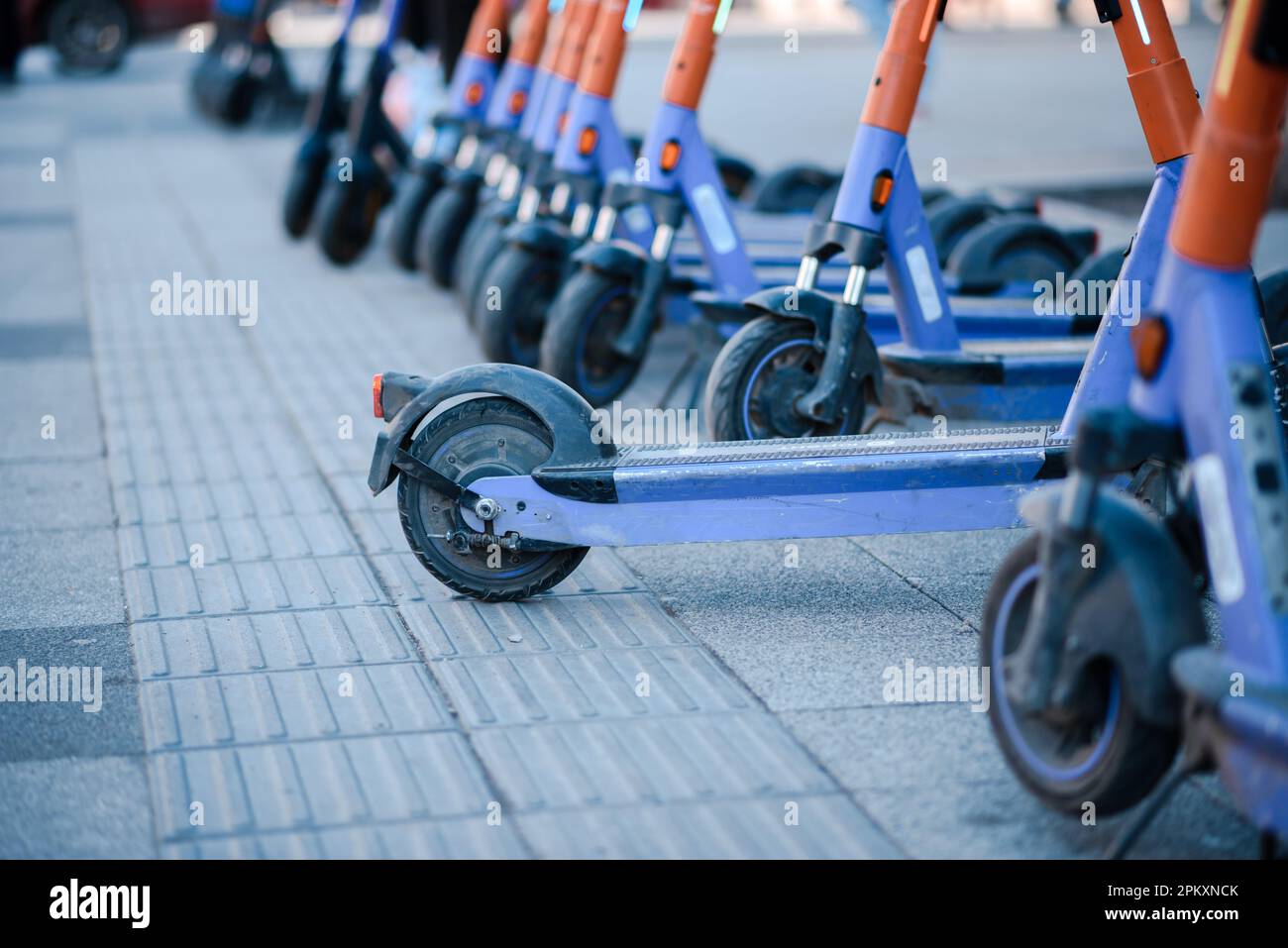Electric scooters are parked in the city center. Public mobile transport stand outside Stock