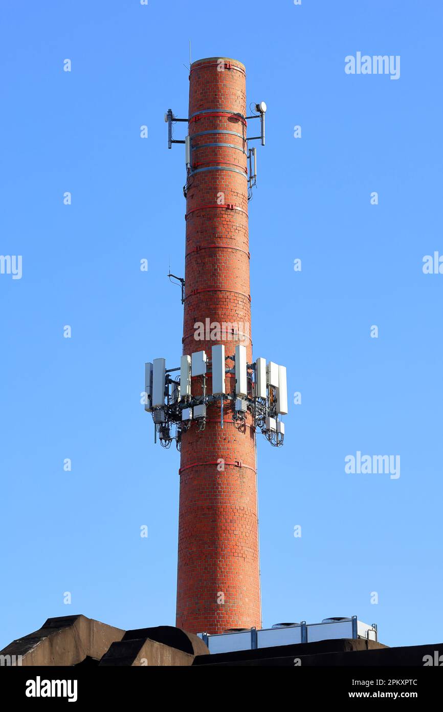 Telecom equipment and cellphone antennas installed on an industrial masonry brick chimney converting it into a cellphone tower Stock Photo