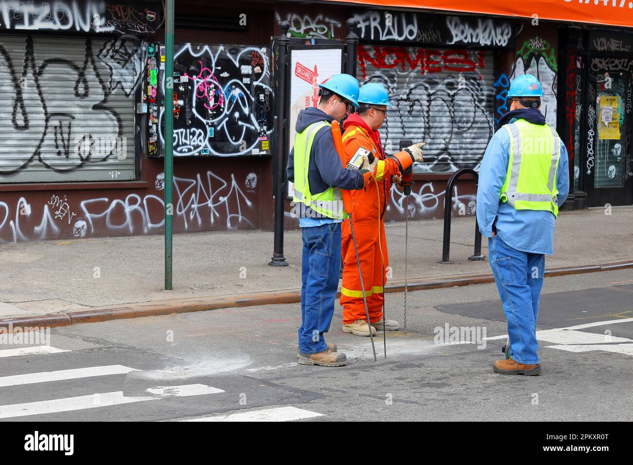 Con Edison gas utility workers with a natural gas detector, survey equipment, and a rotary hammer drill in New York City Stock Photo