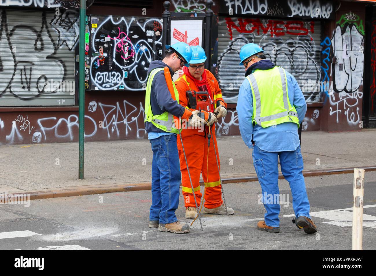 Con Edison gas utility workers with a natural gas detector, survey equipment, and a rotary hammer drill in New York City Stock Photo
