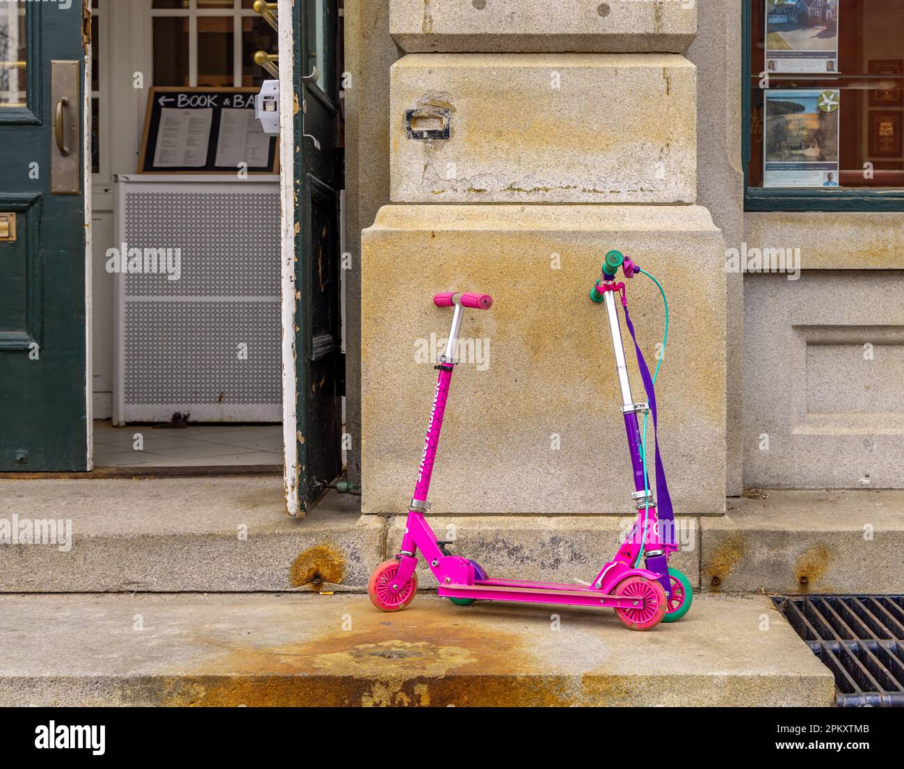 a pair of scooters parked outside a business Stock Photo
