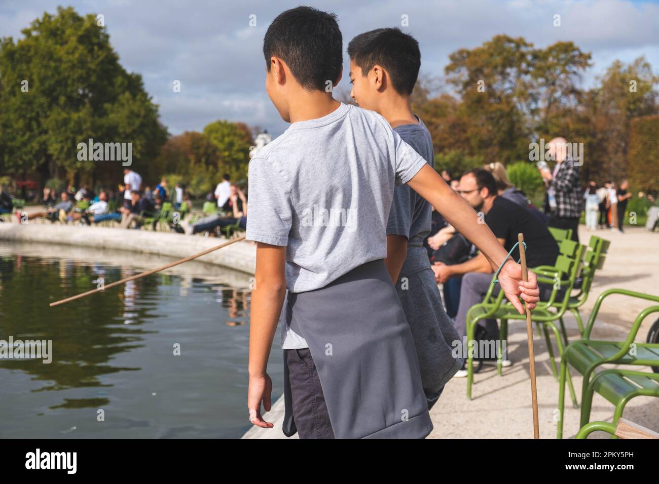 Two Brothers Exploring by the Pond in a Parisian Park Stock Photo