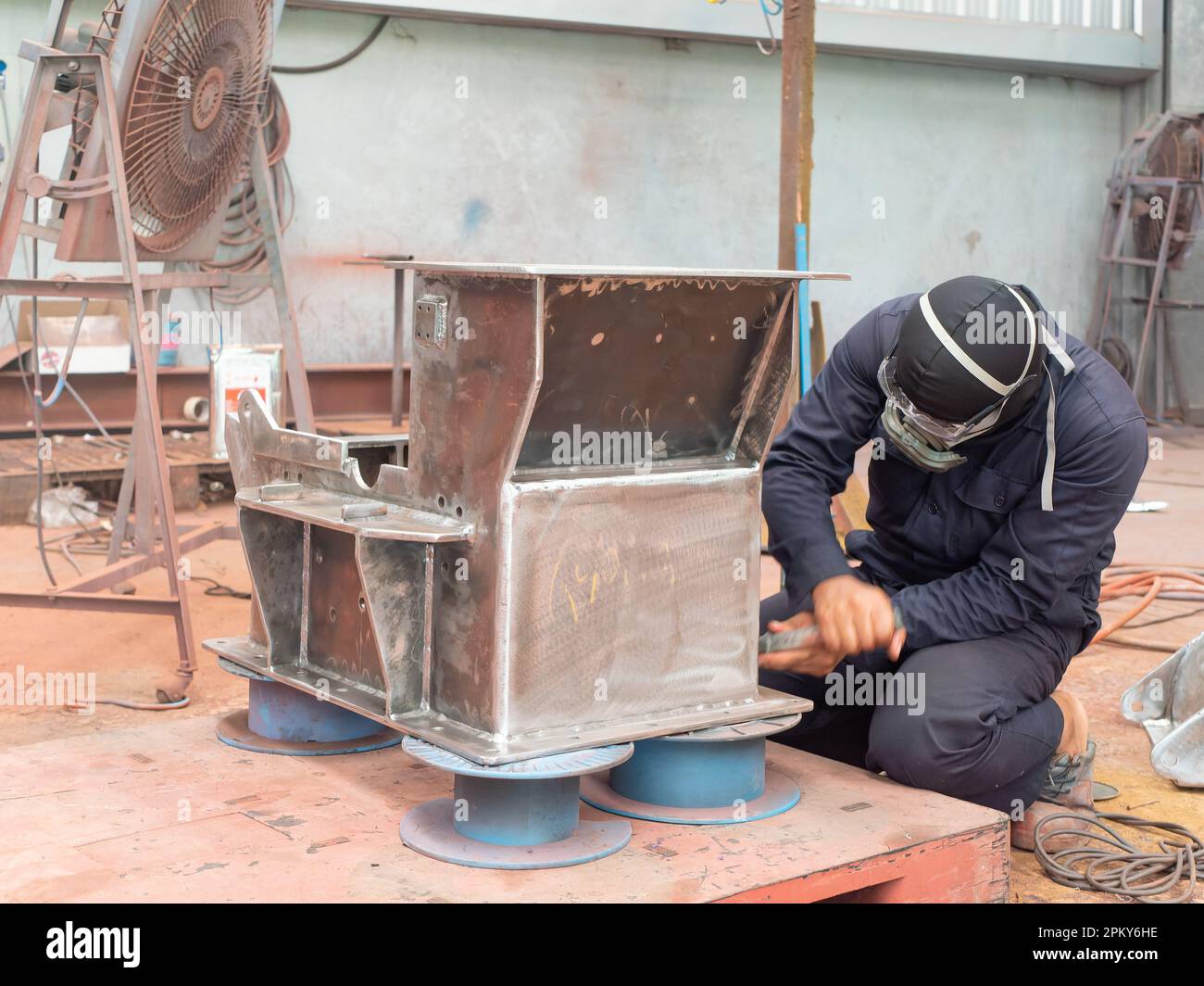 Hammer mill being prepared for spray painting at industrial paint shop