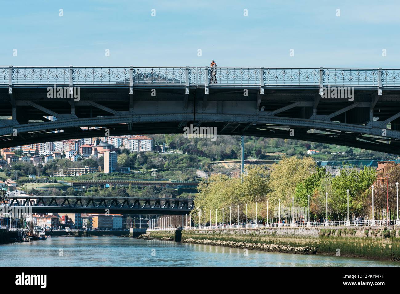 Bilbao, Spain - April 7, 2023: View of pedestrians crossing the Deustuko Zubia Bridge on the River Nerion in Bilbao, Spain Stock Photo