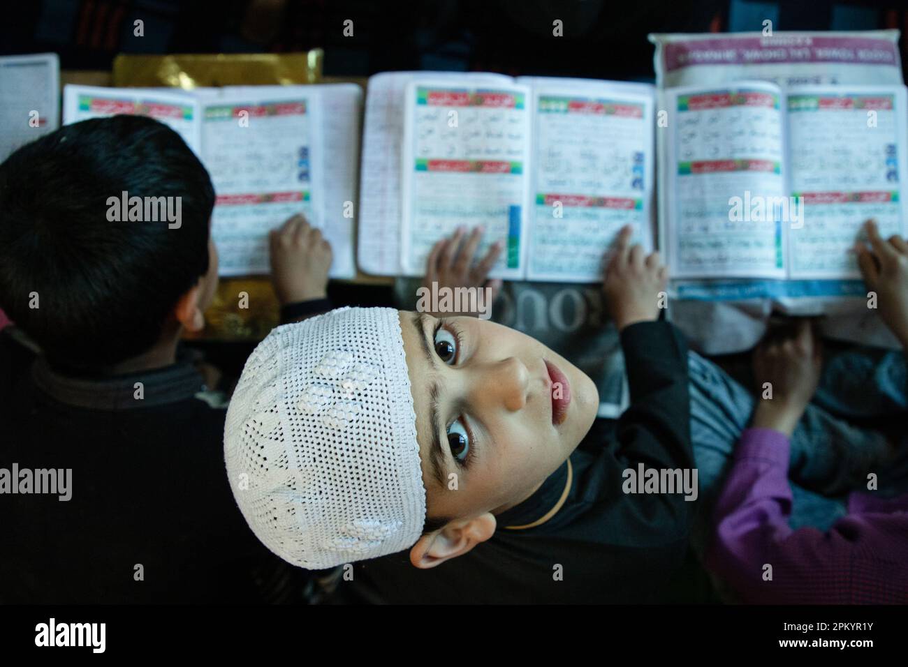 Srinagar, India. 09th Apr, 2023. Kashmiri Muslim boy looks on while reading the holy Quran at a