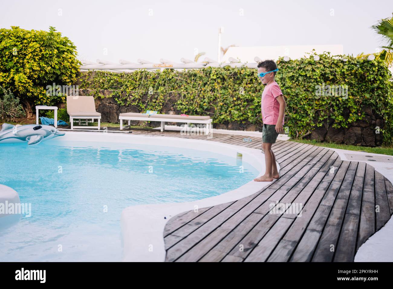 child ready to jump into the pool with clothes on Stock Photo - Alamy