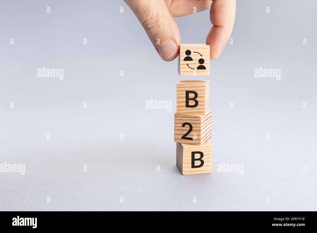 Business to Business B2B concept. Hand putting a block with icon and text word on top of others. Copy space Stock Photo