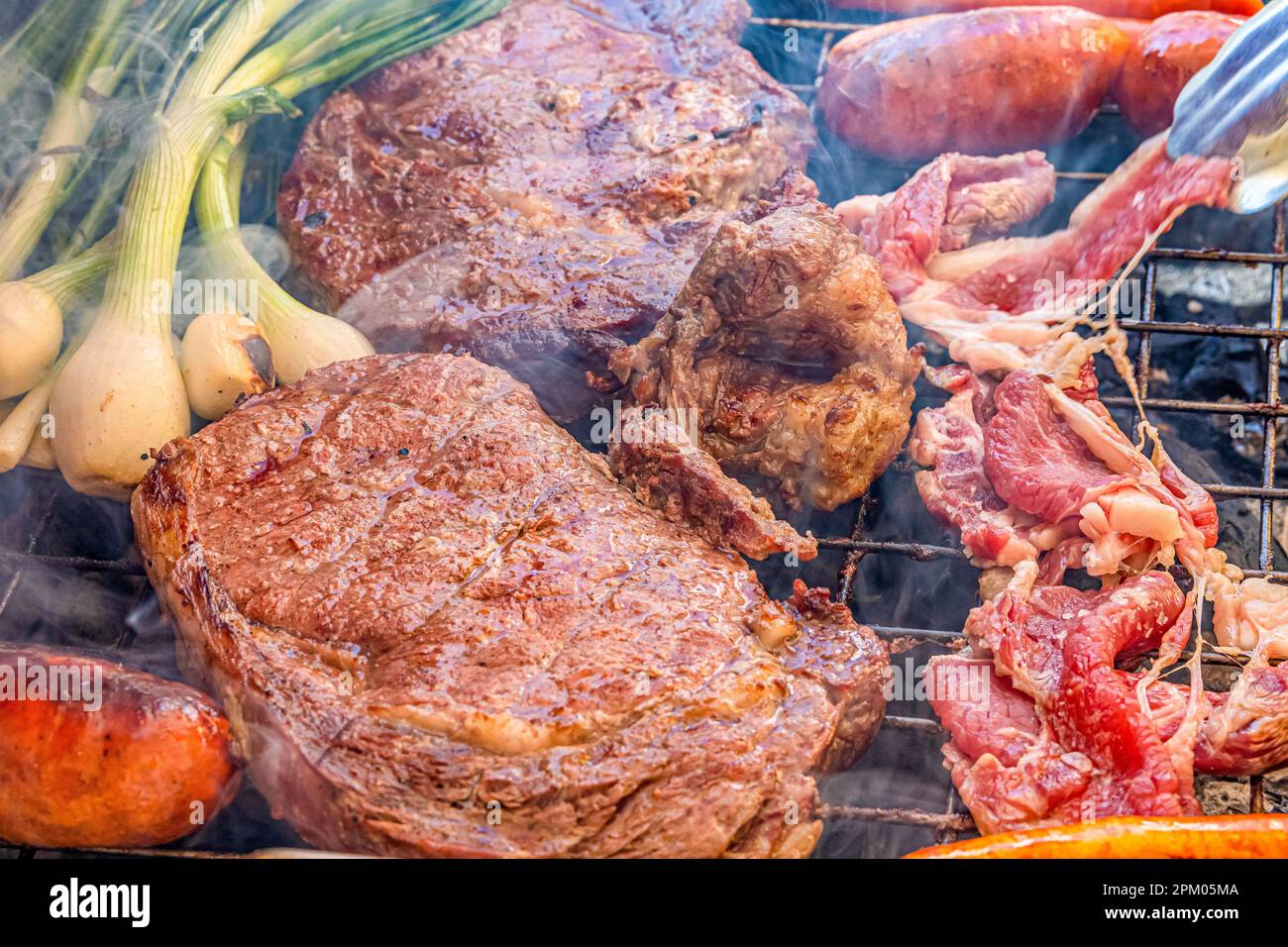 Delicious Mexican barbecue with beef steaks, chorizo and white onions