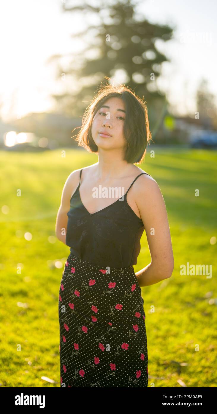 Young Asian Woman Standing in a Grass Field at Golden Hour | Moody Stock Photo