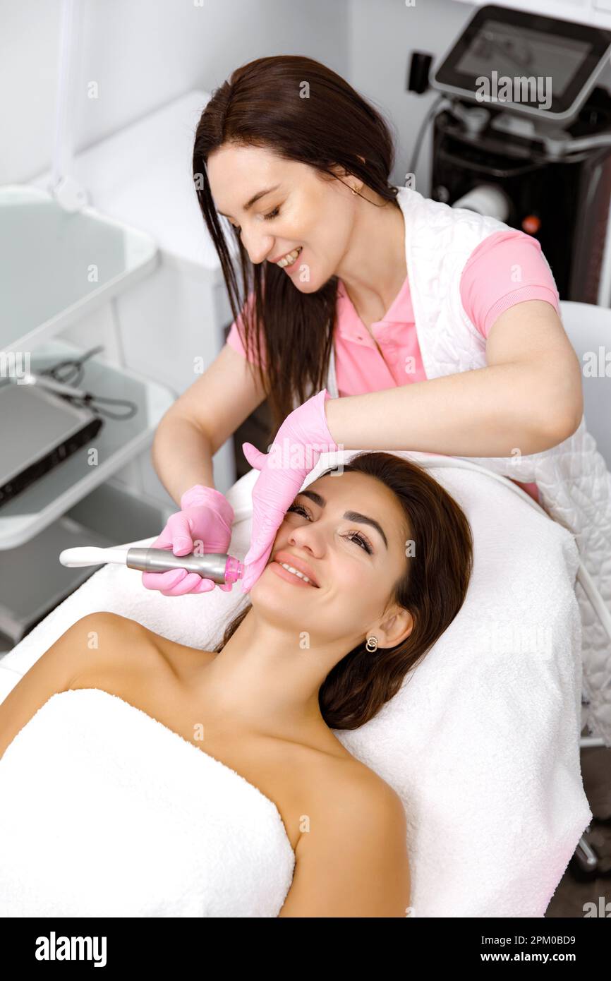 Skin care service,Rejuvenating facials,beauty regimen,Cosmetology service. woman is undergoing a skincare procedure with a cosmetologist Stock Photo