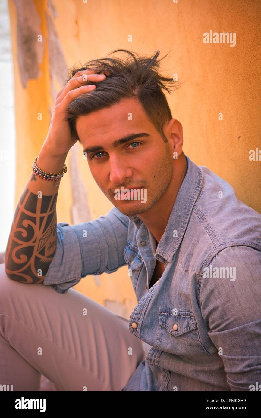 Portrait of handsome man sitting on cement stairs Stock Photo - Alamy