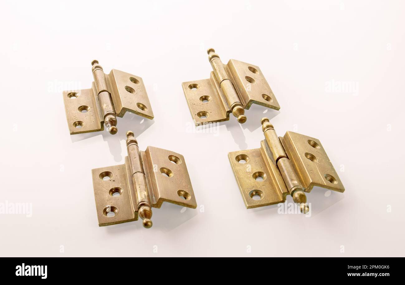 Four brass furniture hinges from the early 20th century with traces of patina Stock Photo Alamy
