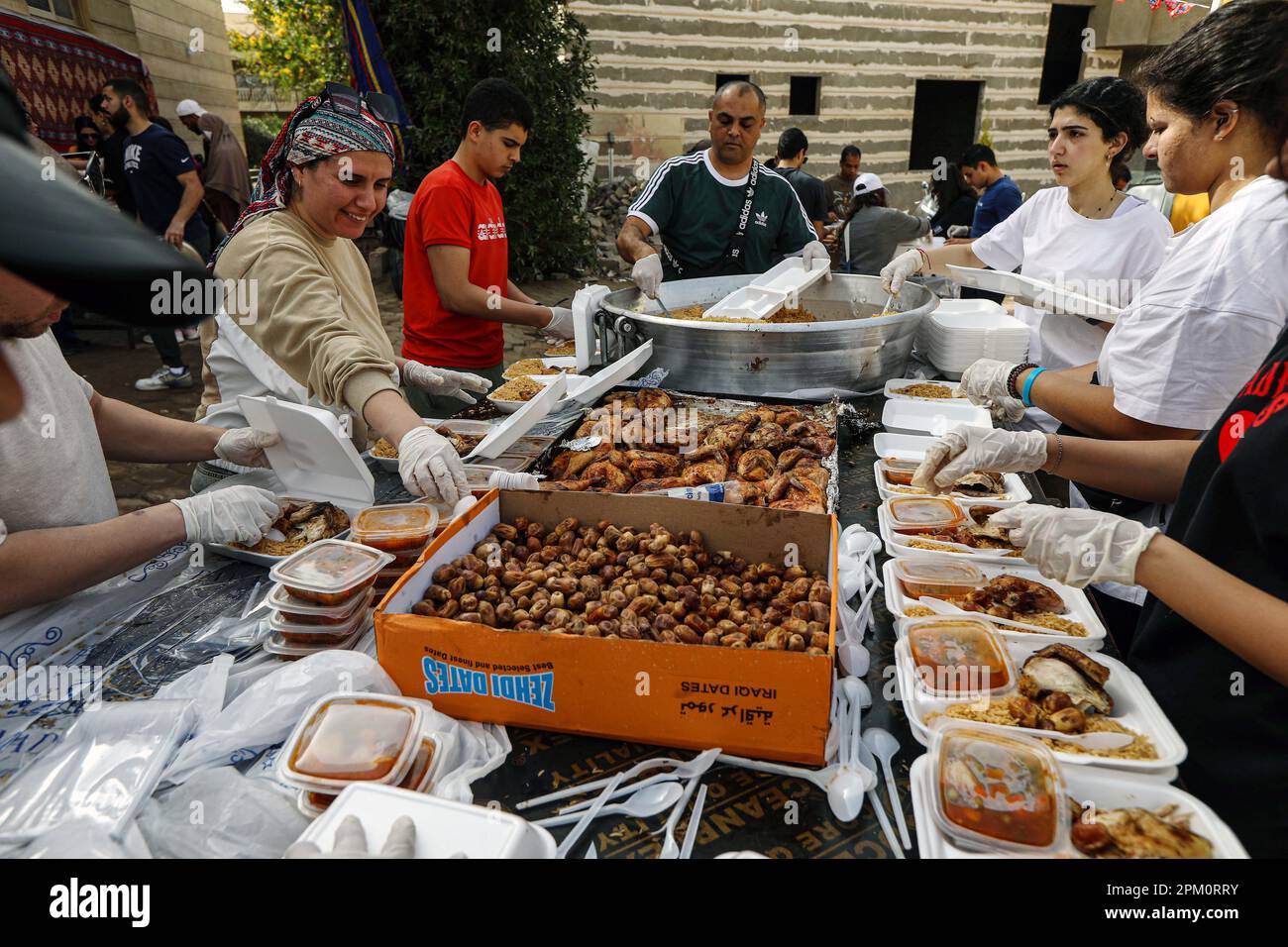 Cairo, Egypt. 9th Apr, 2023. Volunteers pack iftar meals outside Al
