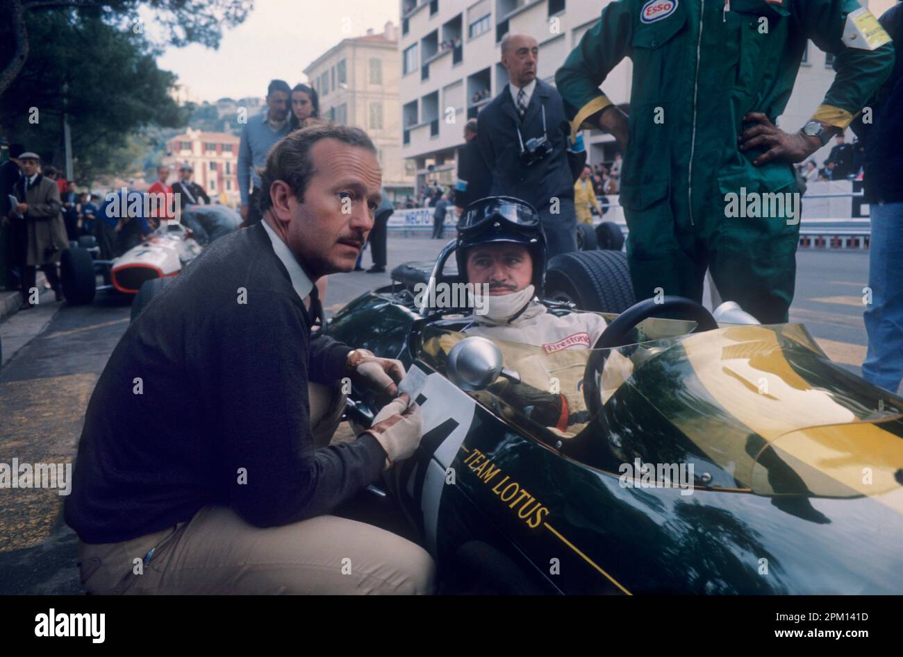 Formula 1: Engineer Colin Chapman talking to driver Graham Hill (twice world champion) in Lotus before Monaco Grand Prix in1967. Stock Photo