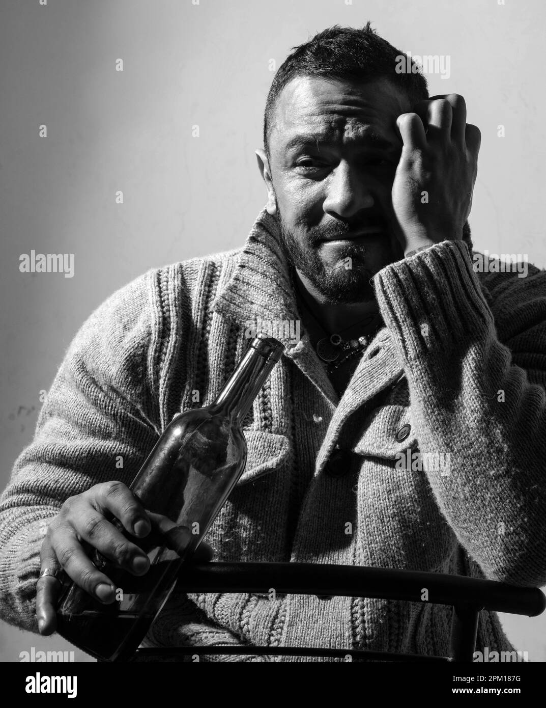 He is a recovering alcoholic. Depressed latino man drinking alcoholic