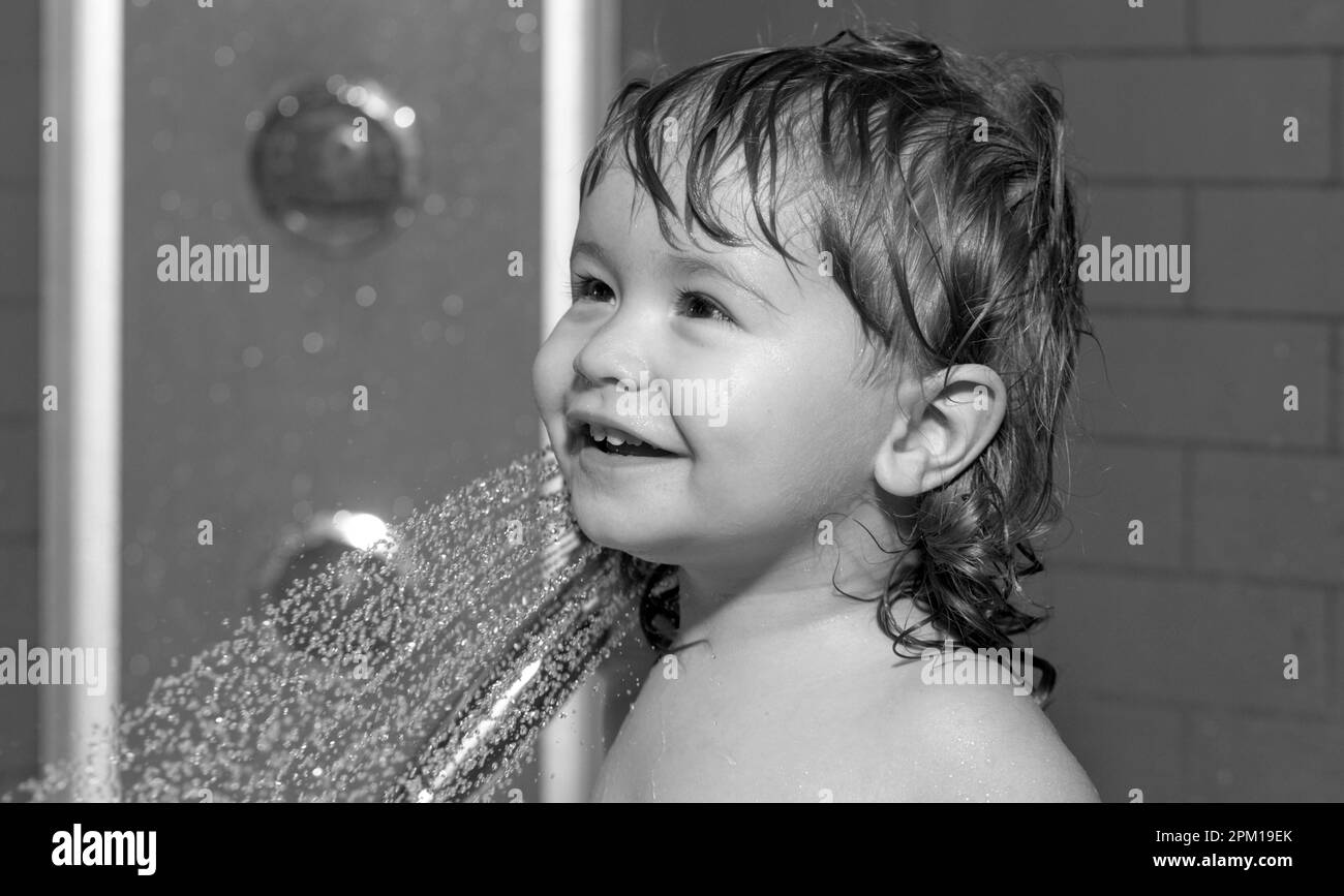 Cute child playing in bathtube. Baby showering. Portrait of kid bathing