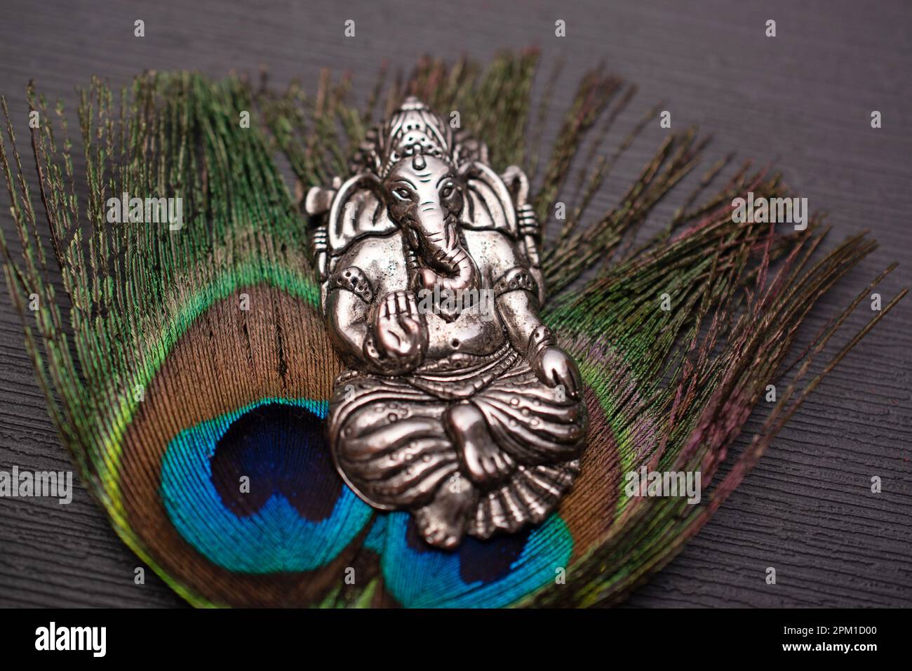 Lord ganesh silver ornament with peacock feather Stock Photo Alamy