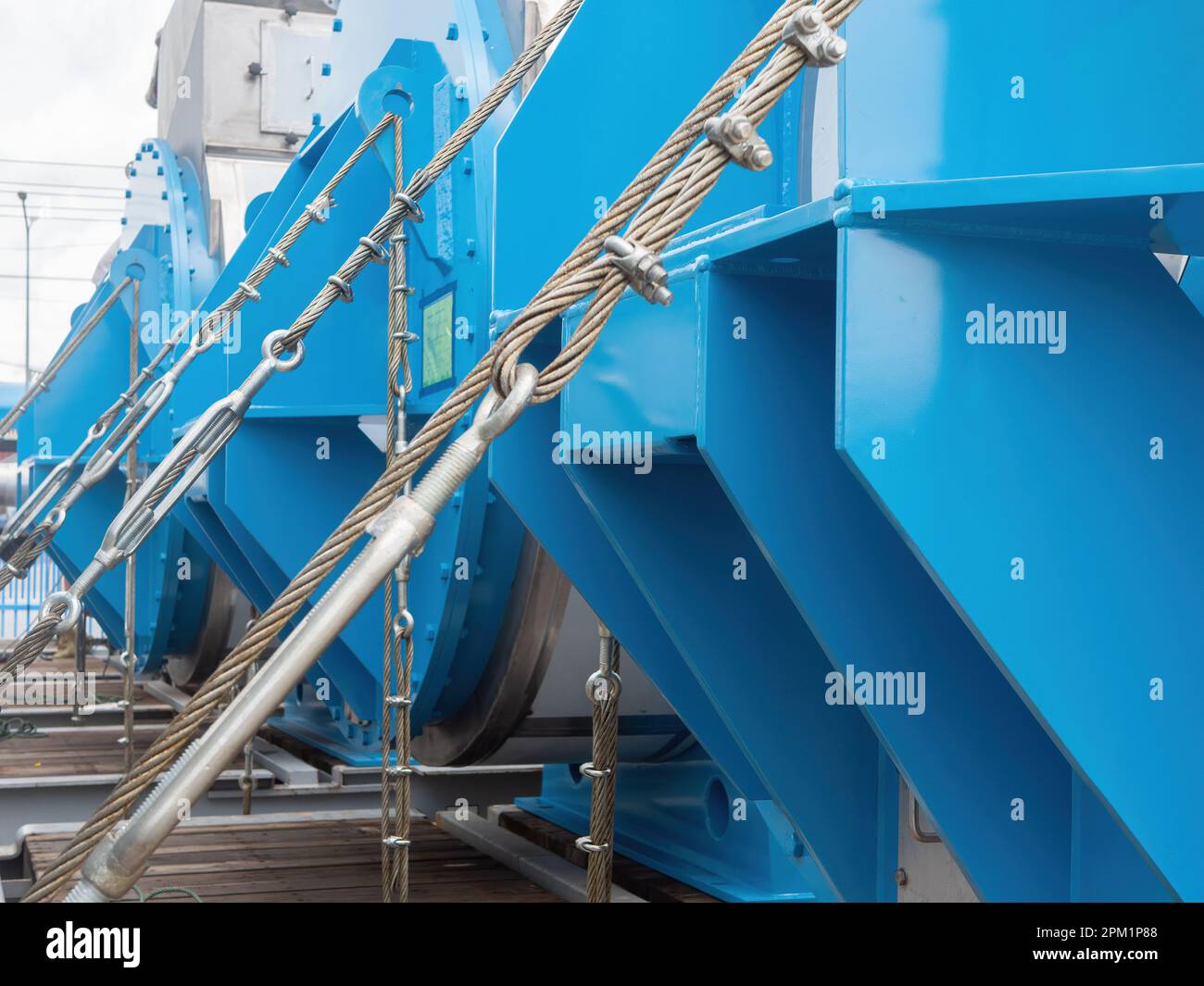 Wire rope with turnbuckles and clamps holding heavy machinery in place ...
