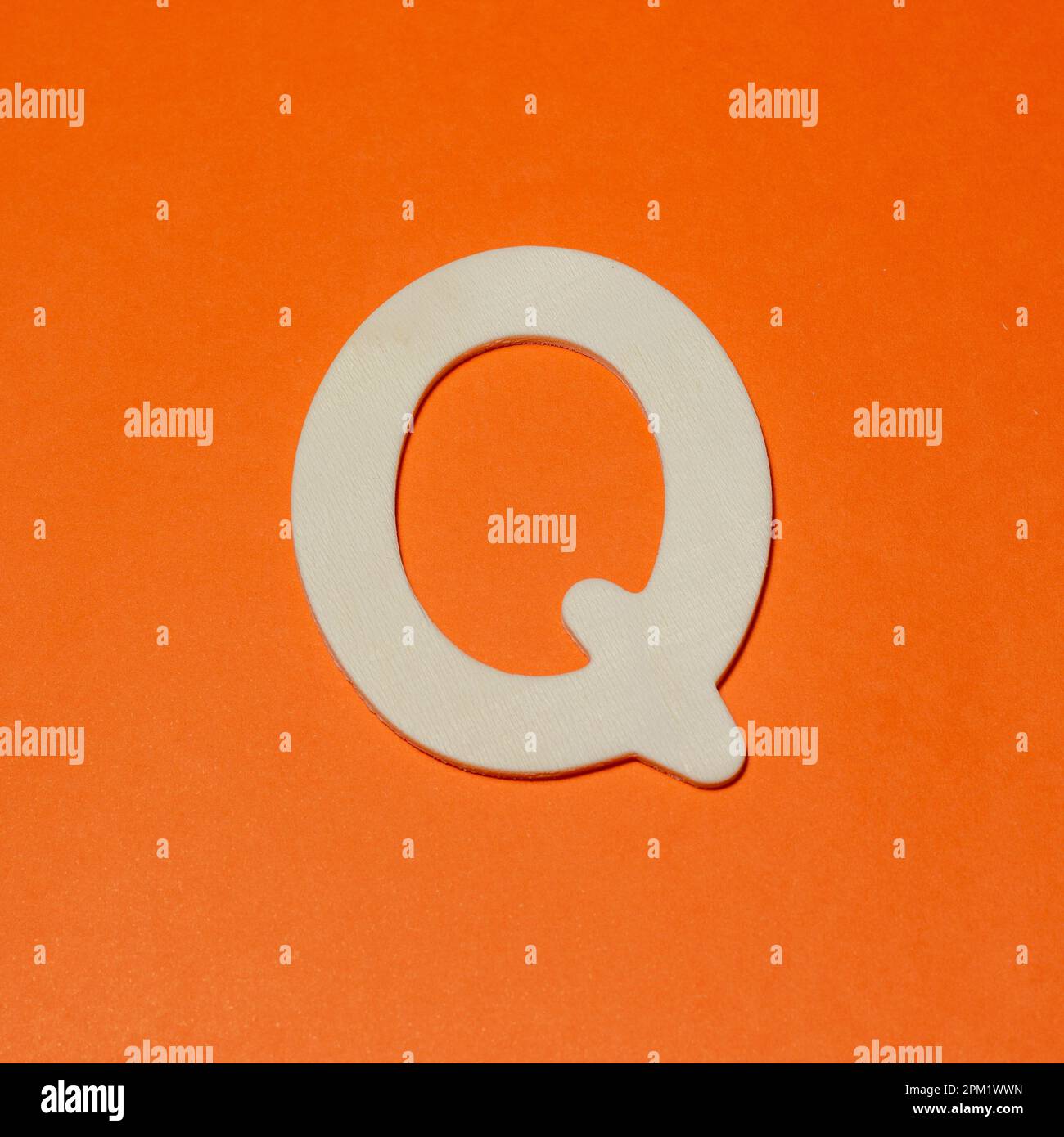 Uppercase letter Q - wood texture - Orange background Stock Photo