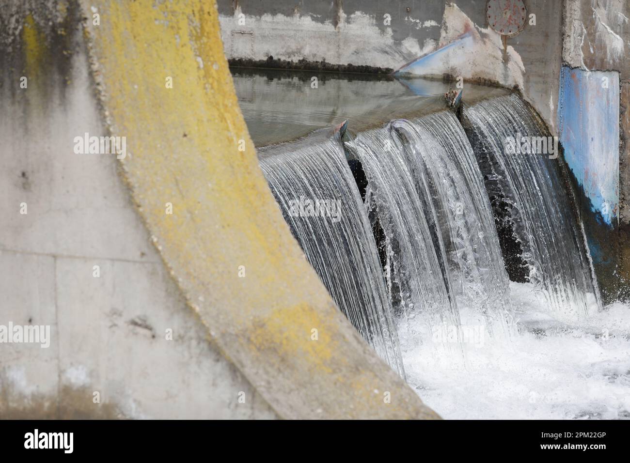 Water flowing through a sluice on a concrete man made river. Stock Photo