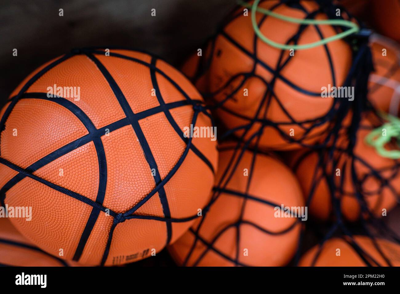 Shallow depth of field (selective focus) details with a cheap plastic basketball in a heap in a public school. Stock Photo