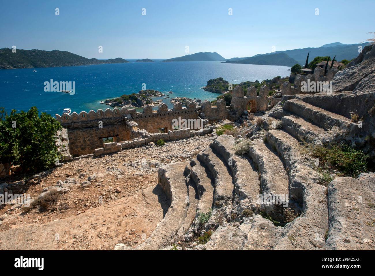 The view from the ruins of the ancient theatre within the Crusader Fortress at Simena which sits above the Mediterranean town of Kalekoy in Turkiye. Stock Photo