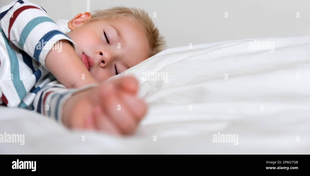 Sleeping Child in Bed. Cute Little Kid Sleeps Sweetly on Cozy White