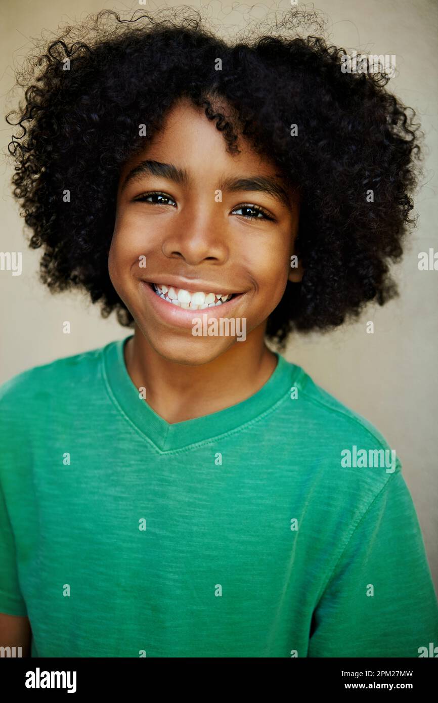 Try and find a bigger smile. Studio portrait of a young boy giving you