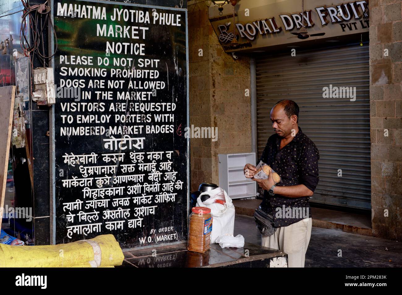 A notice board in Mahatma Jyotiba Phule Market (Crawford Market)  Mumbai, India, prohibits smoking and dogs, and requests to only employ legal porters Stock Photo