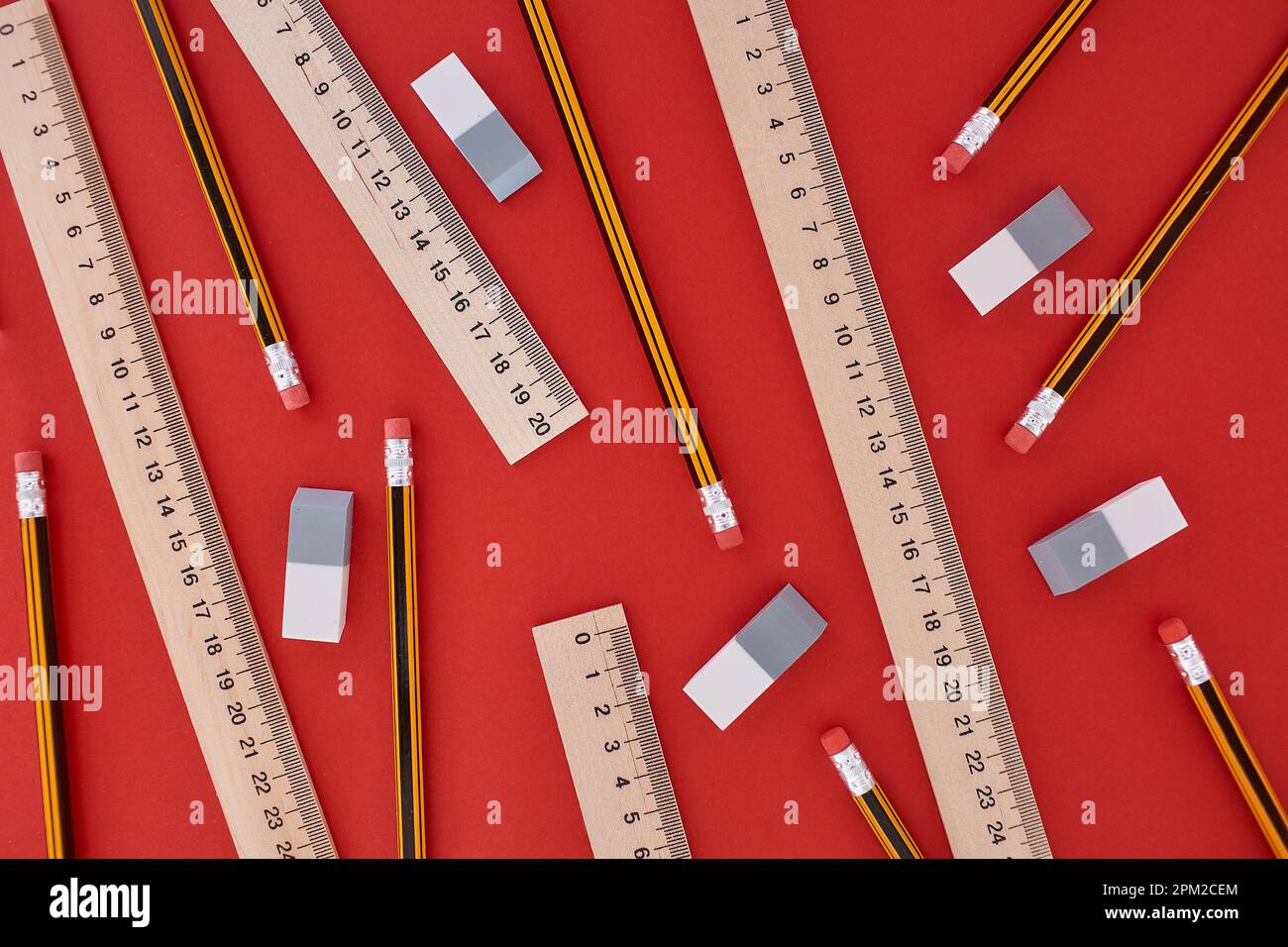 Randomly located many pencils, lines and erasers in top view at the red