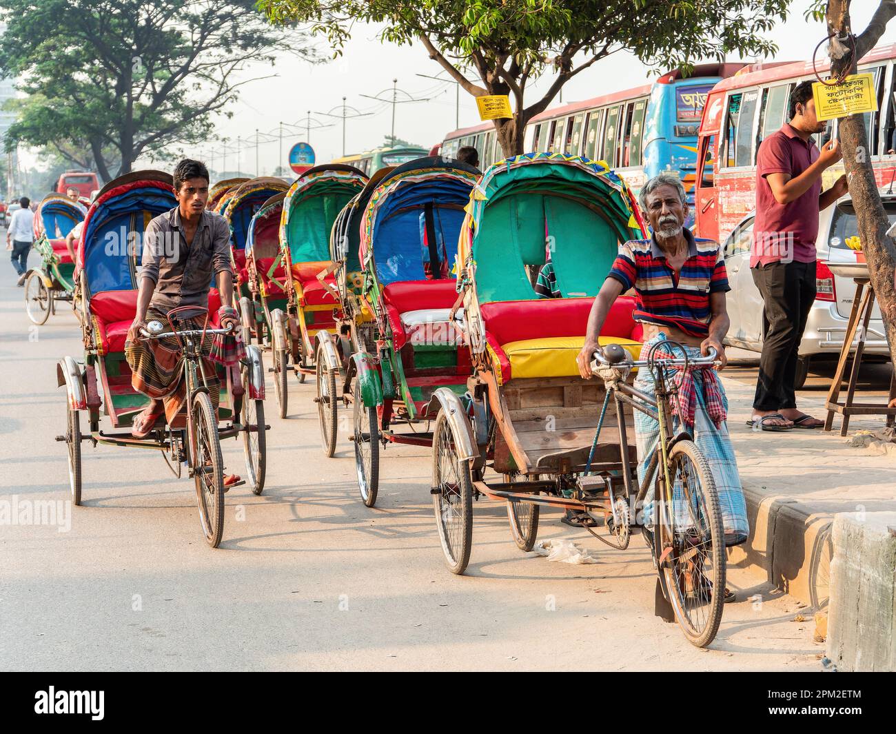 Tricycle taxis waiting for passengers at a main road in Dhaka