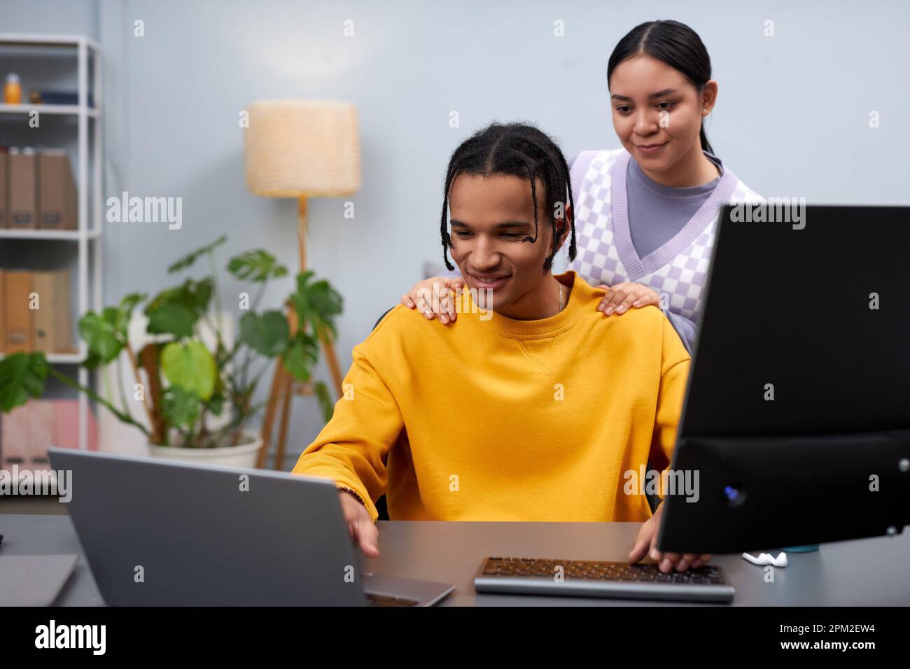 Portrait of two young people man and woman reviewing code together ...