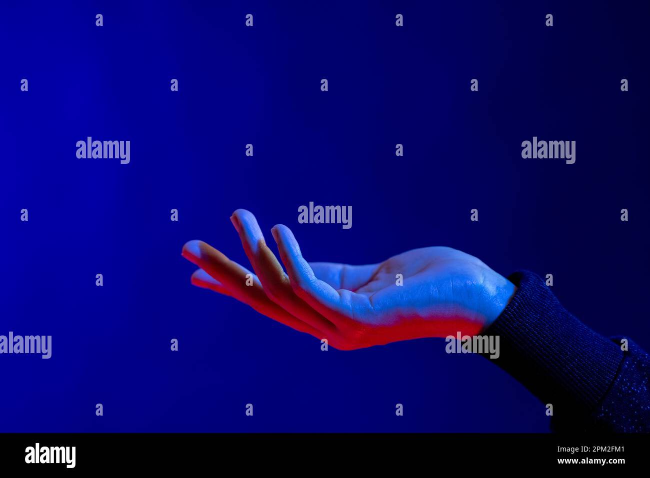 Exposed hand in studio with blue light with copy space Stock Photo