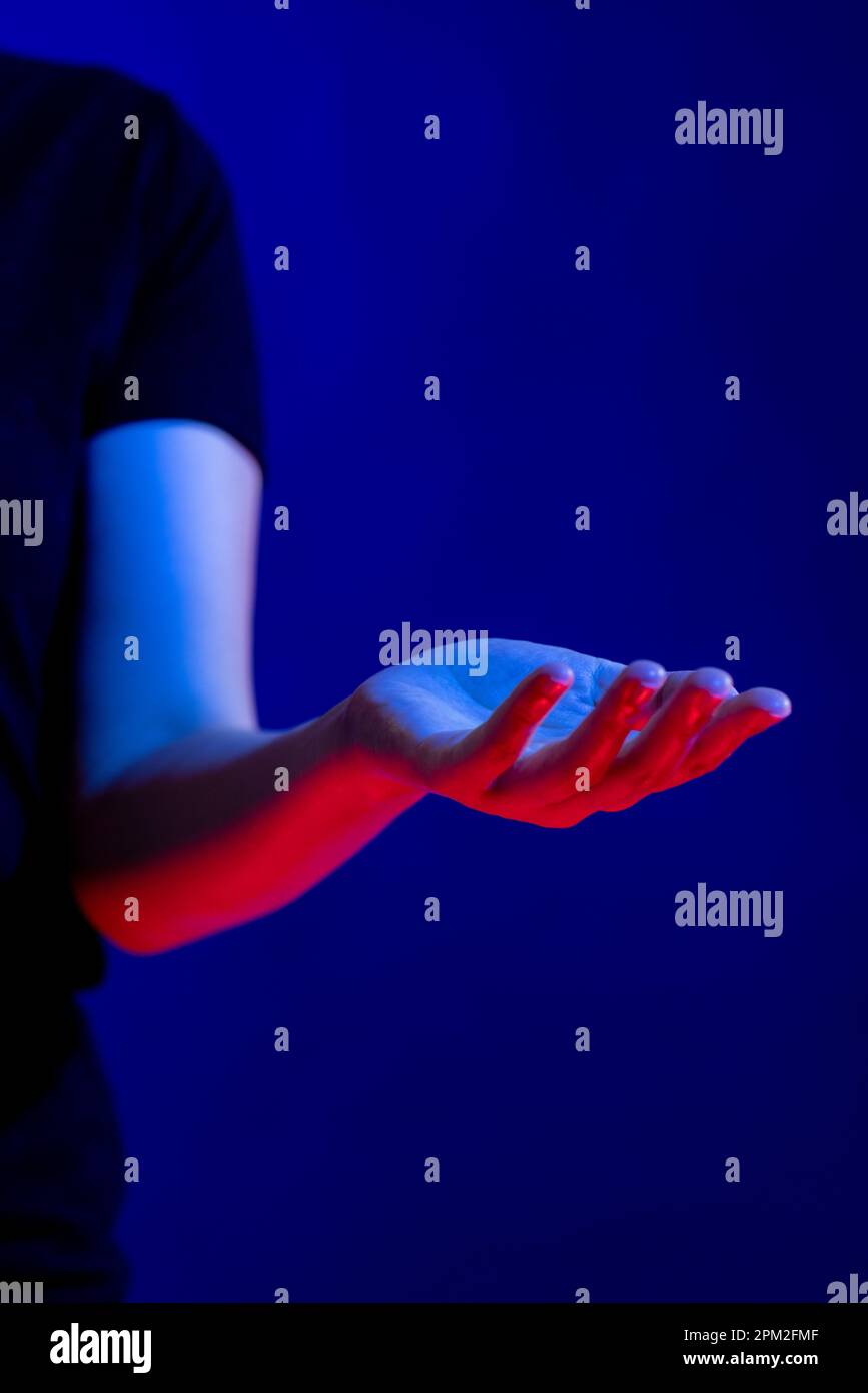 Exposed hand in studio with blue light with copy space Stock Photo