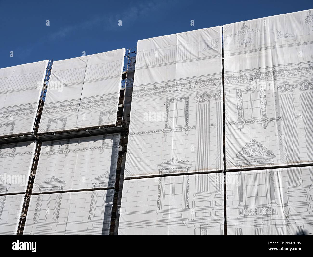 Scaffolding shroud with architecture drawing hiding the reconstruction of old building Stock Photo