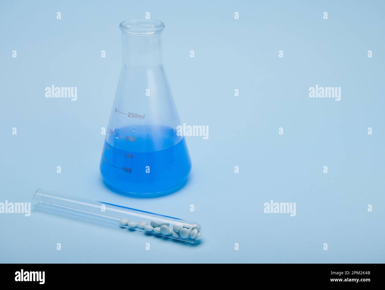 Graduated flat bottomed lab flask with blue fluid chemical solution and